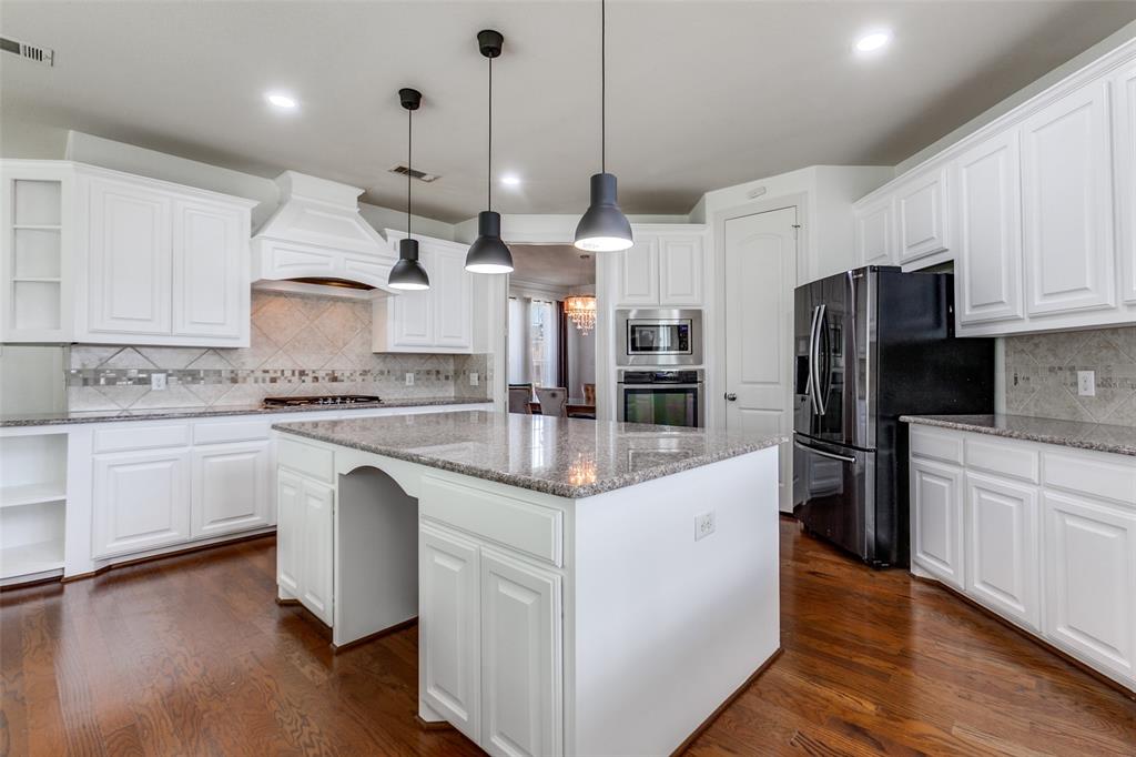 3620 Acropolis Way Plano, TX 75074 - Photo 7 of 25 a kitchen with stainless steel appliances kitchen island granite countertop a sink and a refrigerator