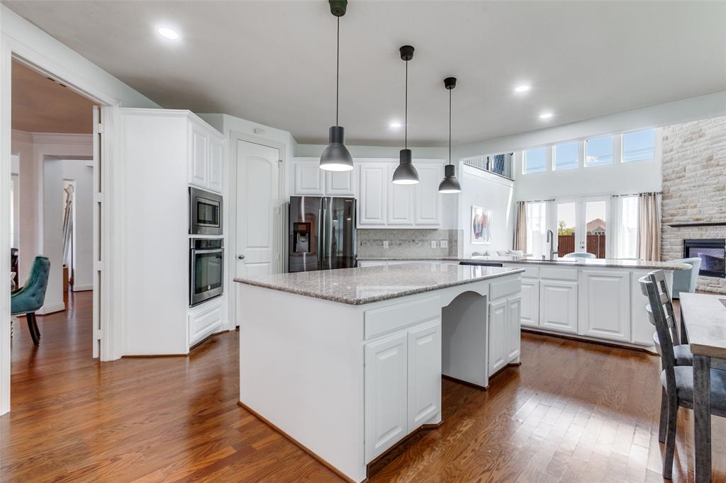 3620 Acropolis Way Plano, TX 75074 - Photo 8 of 25 a kitchen with stainless steel appliances kitchen island a large island in the center and cabinets