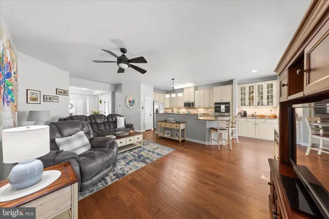 a kitchen with stainless steel appliances granite countertop a stove a sink and white cabinets with wooden floor