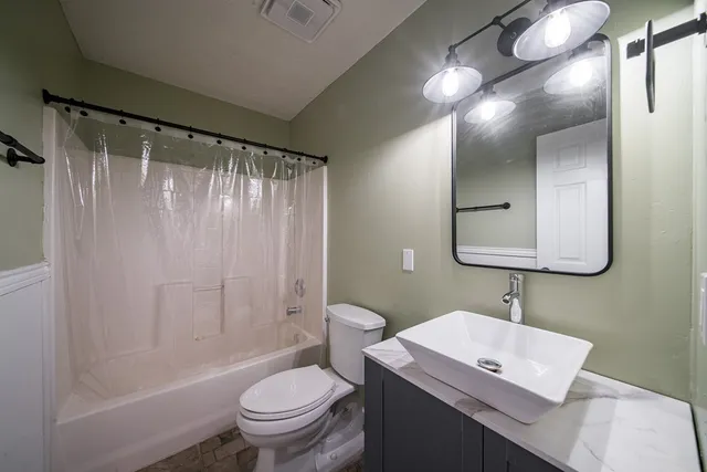 a bathroom with a granite countertop sink toilet and shower