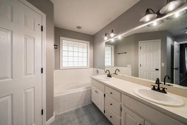 a bathroom with 2 sink tub and a mirror
