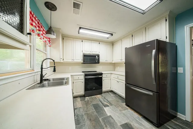 a kitchen with stainless steel appliances granite countertop a refrigerator sink and stove