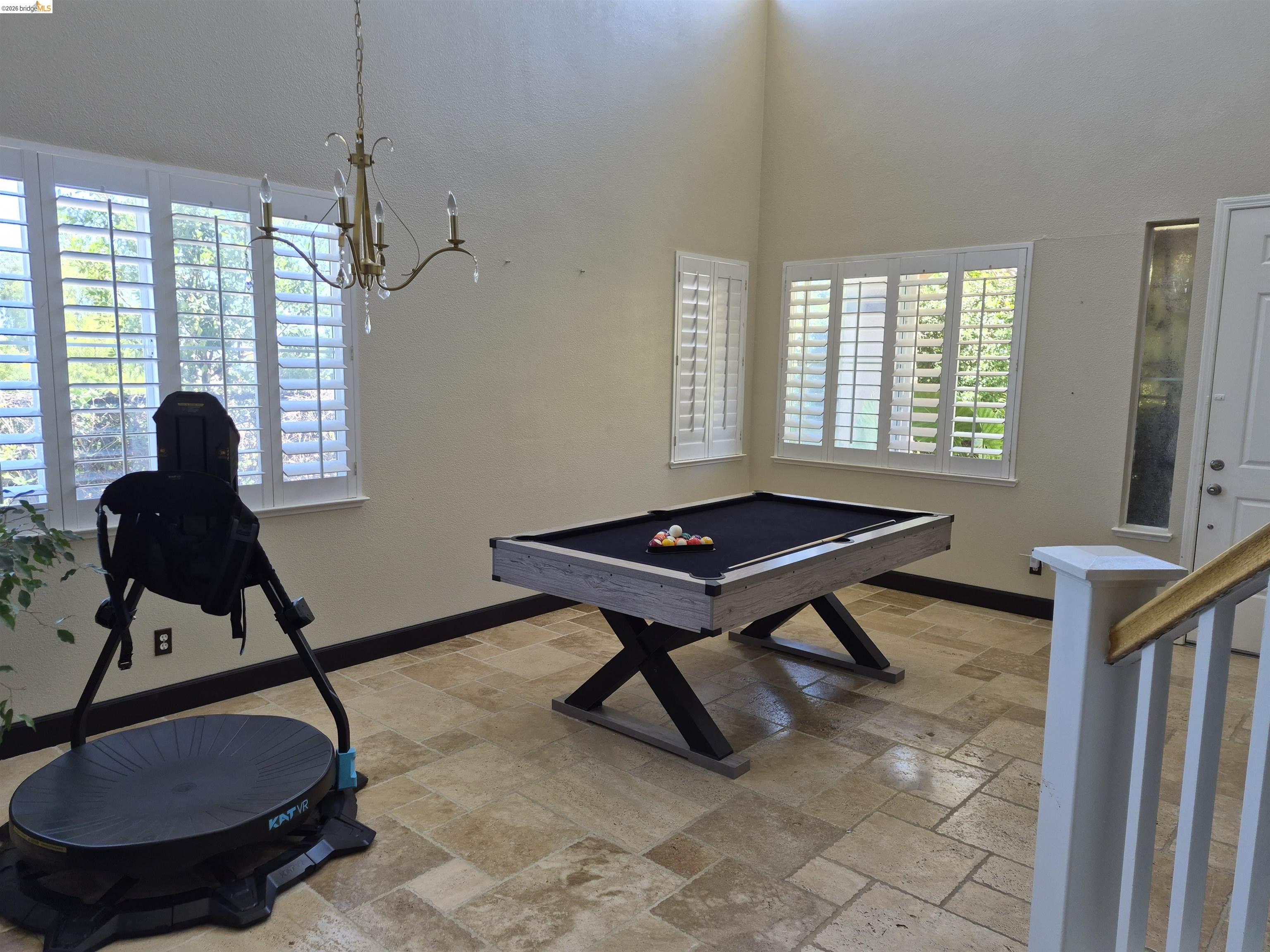 149 Oakpoint Court Bay Point, CA 94565 - Photo 5 of 22 Spacious room featuring high ceilings, light-toned wall paint, plantation shutters, and large format tile flooring