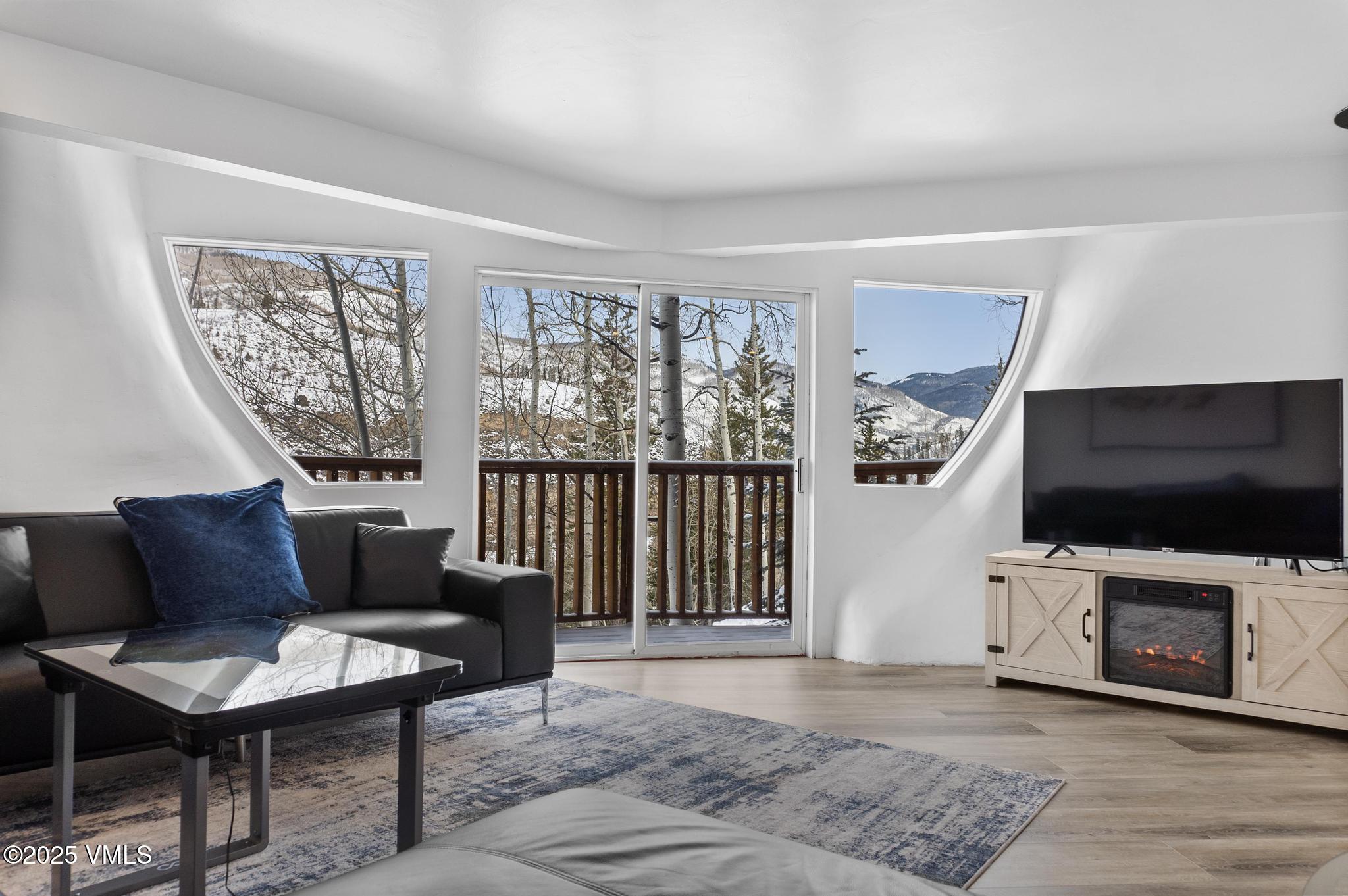 2940 Basingdale Boulevard, Unit 2 Vail, CO 81657 - Photo 10 of 28 a living room with furniture a flat screen tv and a floor to ceiling window