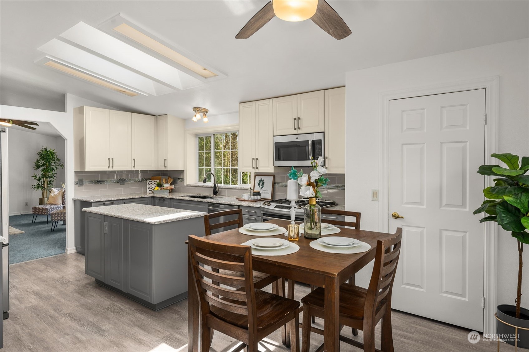 30216 Thomas Road Southeast Kent, WA 98042 - Photo 4 of 37 a kitchen with a dining table chairs and white cabinets