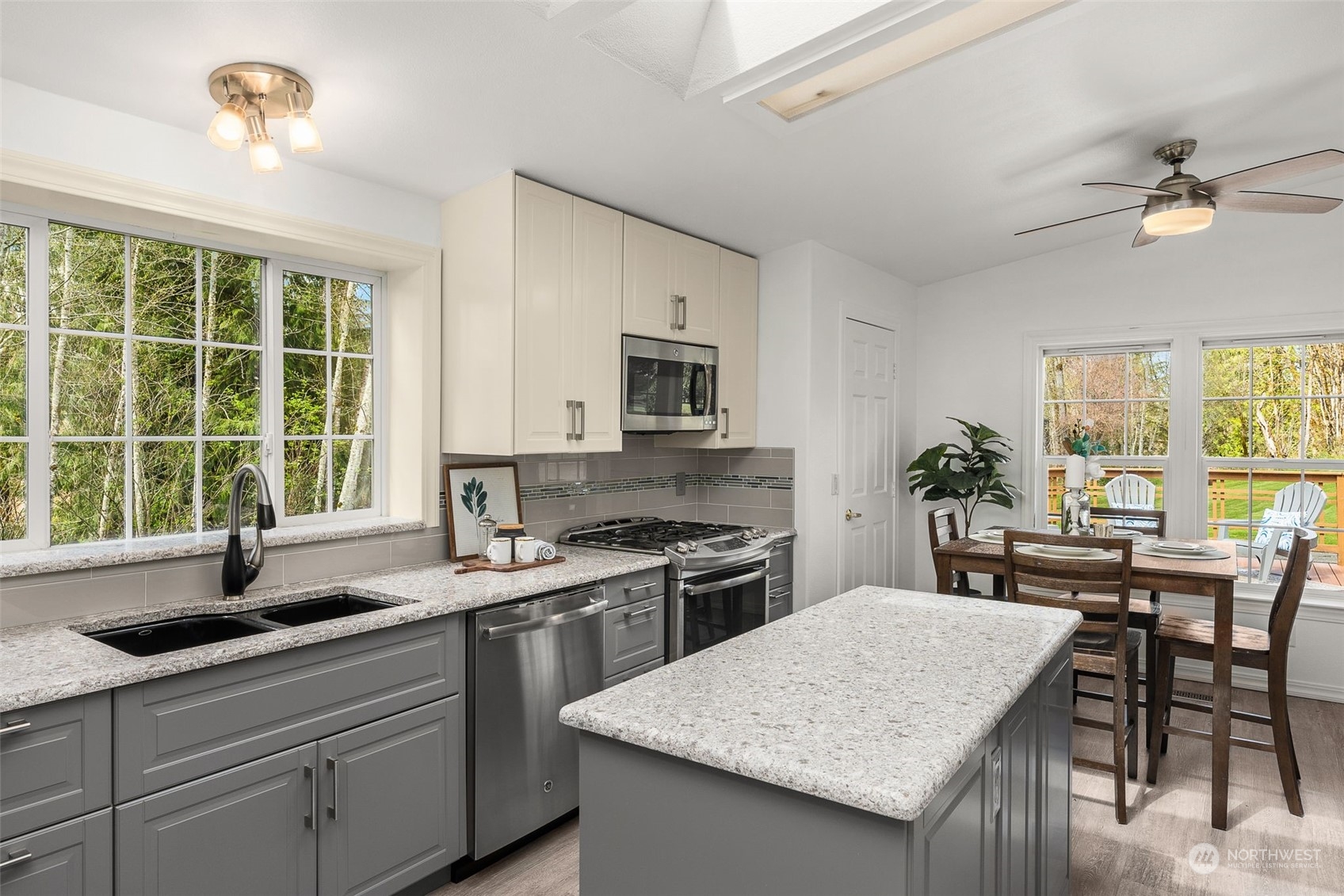 30216 Thomas Road Southeast Kent, WA 98042 - Photo 6 of 37 a kitchen with a stove a sink a dining table and chairs