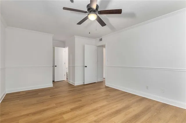 a view of an empty room with wooden floor and cabinet