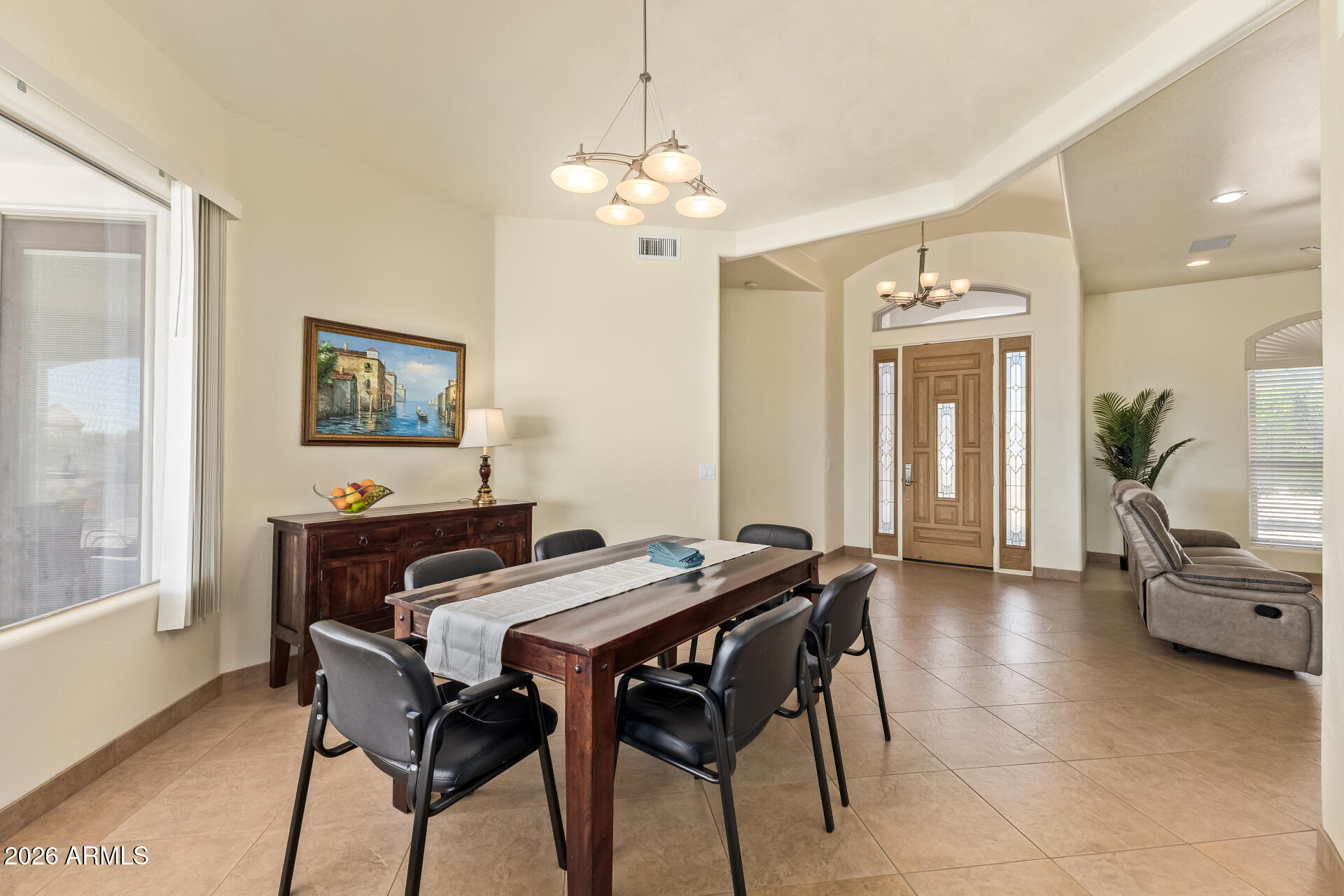 16037 West Wade Lane Goodyear, AZ 85338 - Photo 11 of 67 a view of a dining room with furniture and a chandelier