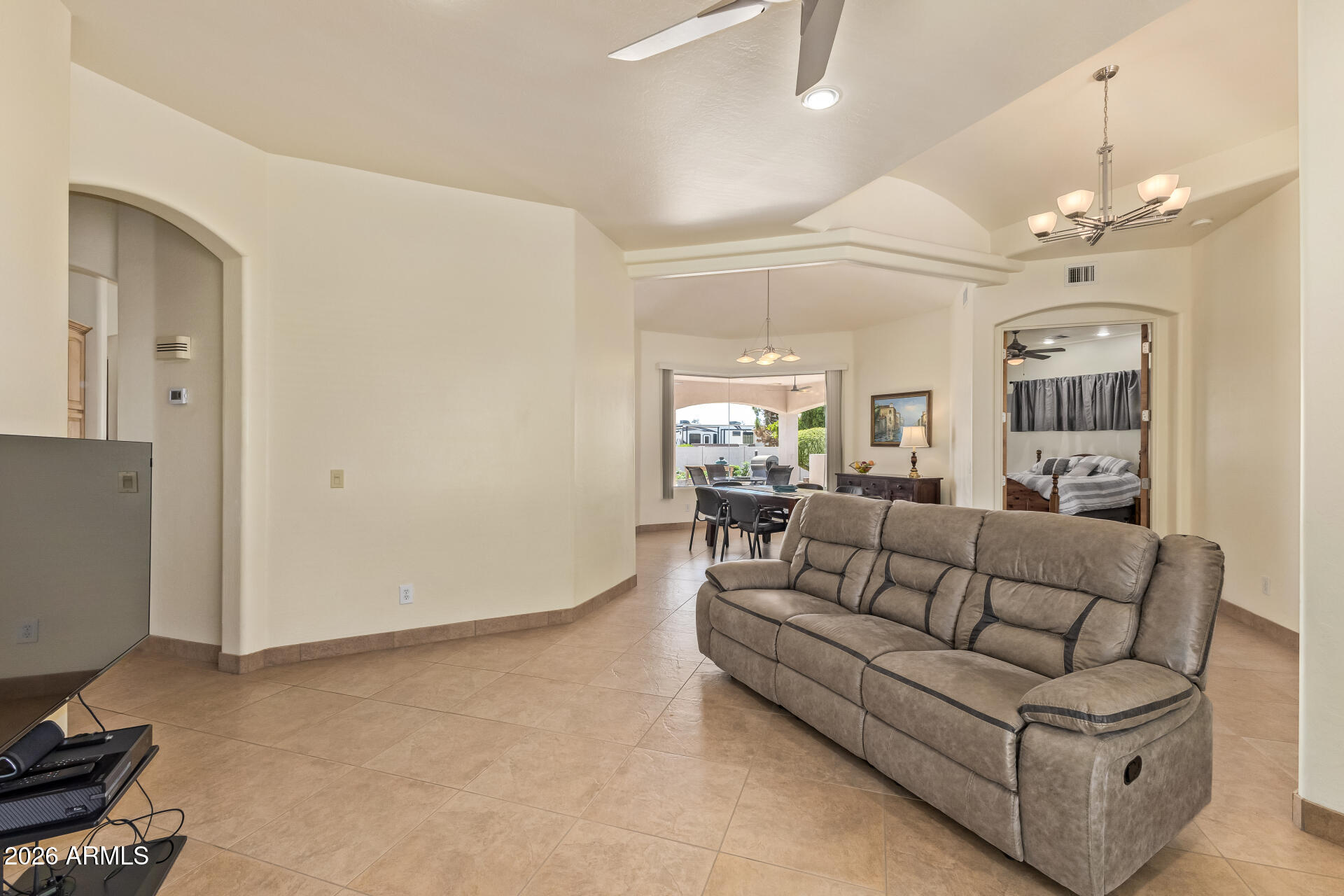 16037 West Wade Lane Goodyear, AZ 85338 - Photo 13 of 67 a living room with furniture a chandelier and a dining table
