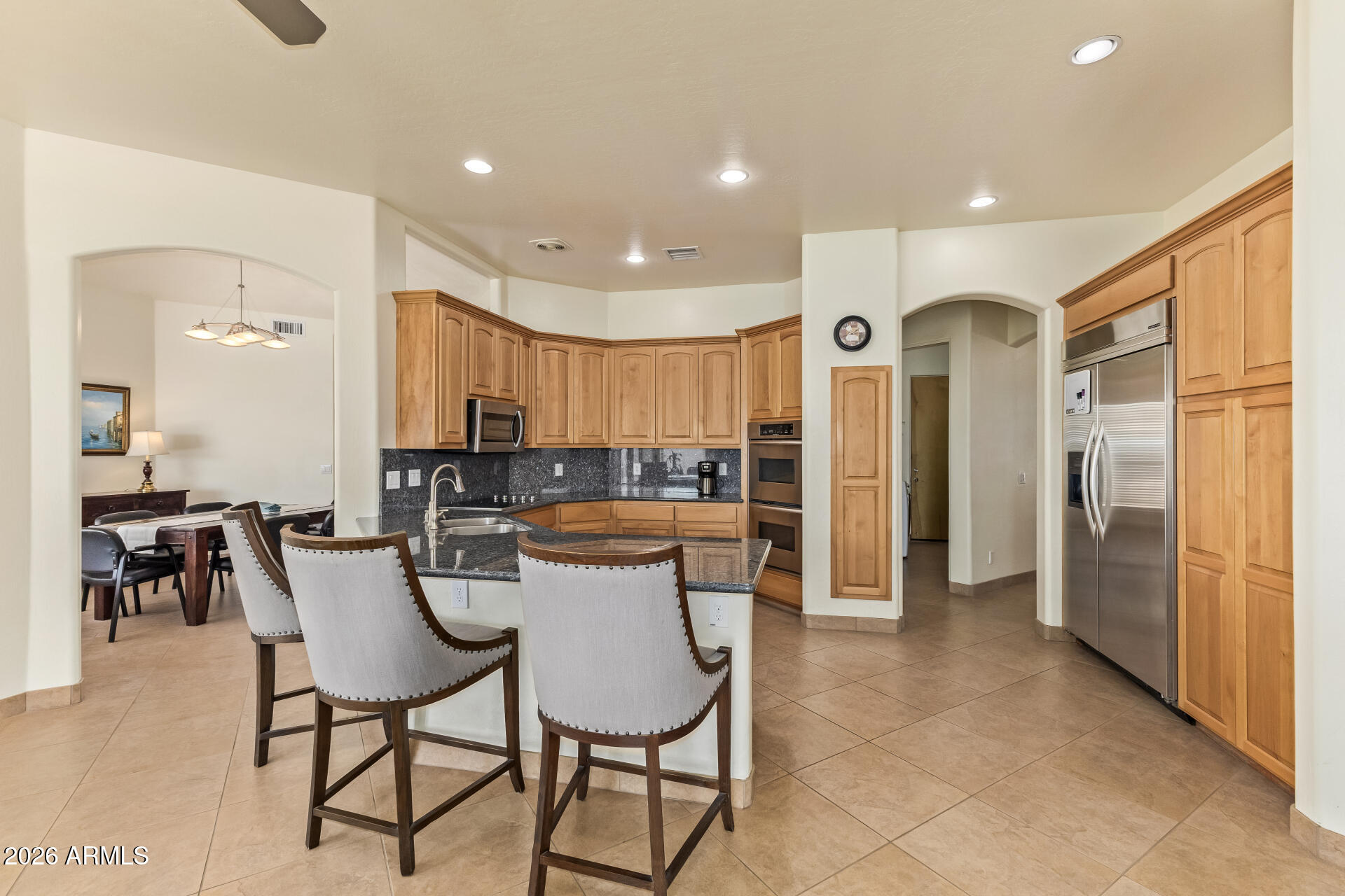 16037 West Wade Lane Goodyear, AZ 85338 - Photo 17 of 67 a kitchen with stainless steel appliances kitchen island granite countertop a refrigerator and a dining table
