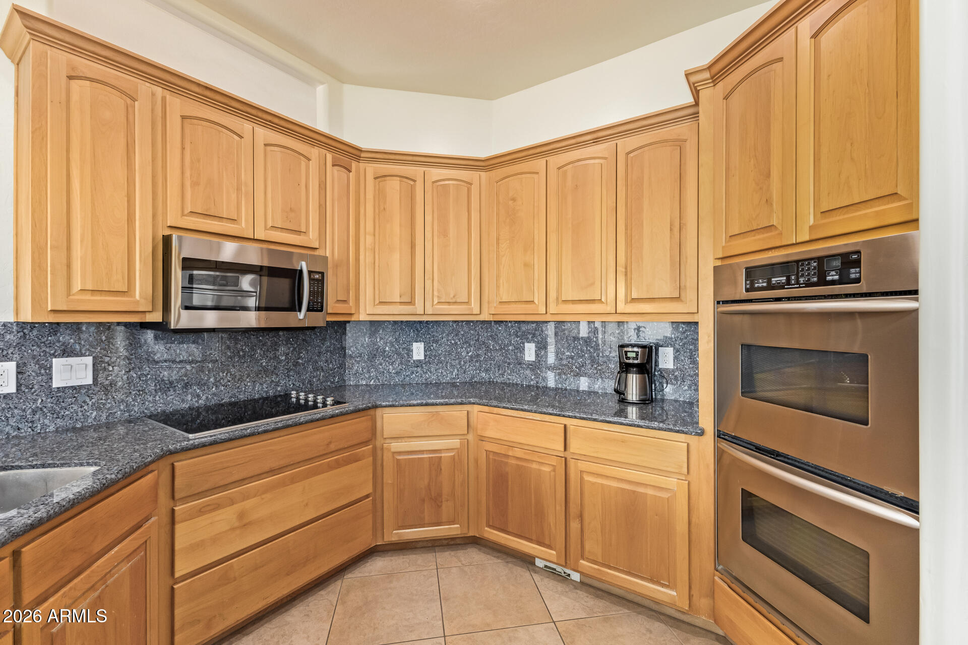 16037 West Wade Lane Goodyear, AZ 85338 - Photo 21 of 67 a kitchen with granite countertop cabinets stainless steel appliances and a sink