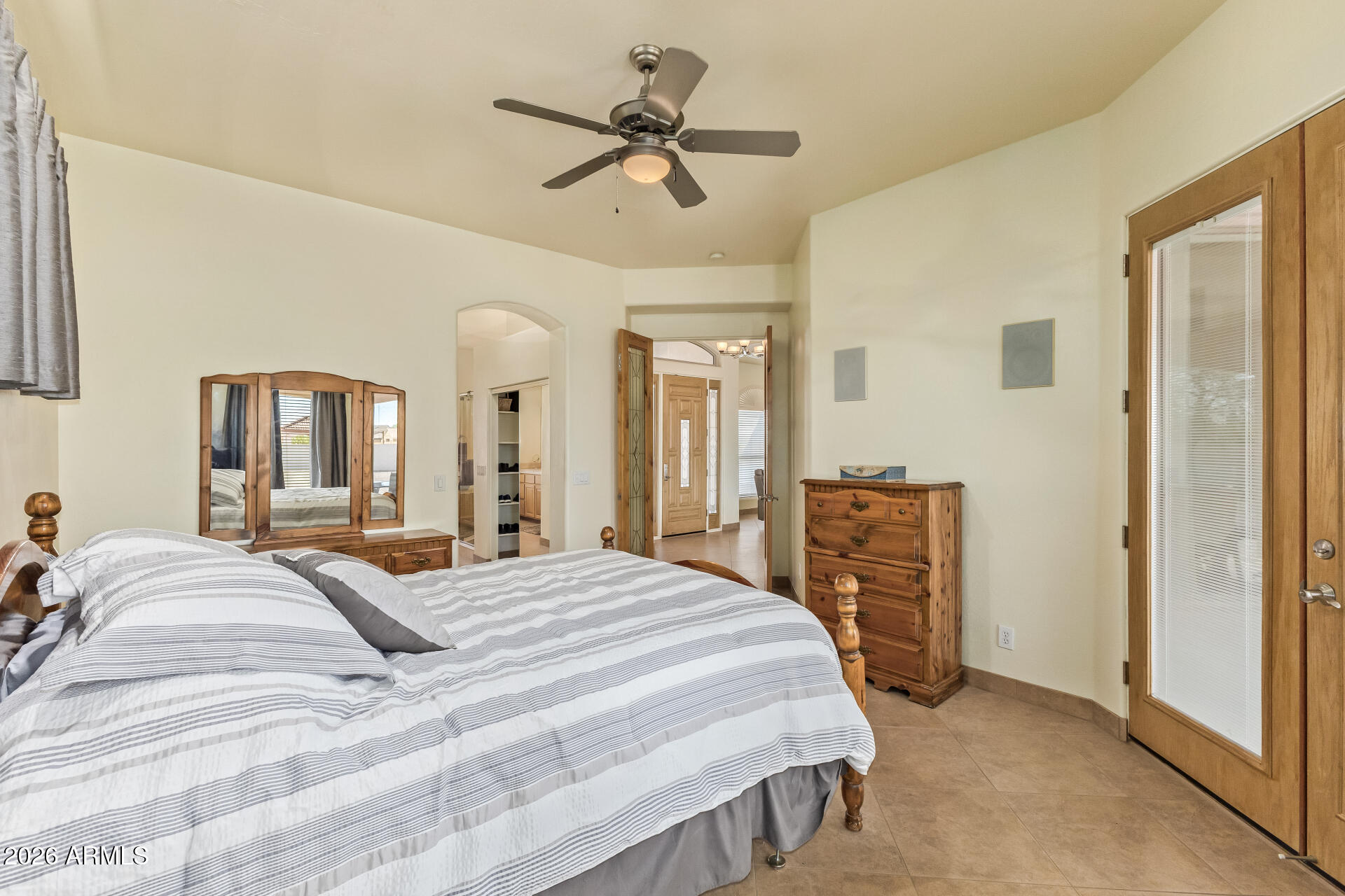 16037 West Wade Lane Goodyear, AZ 85338 - Photo 25 of 67 a bedroom with a bed a ceiling fan and a dresser