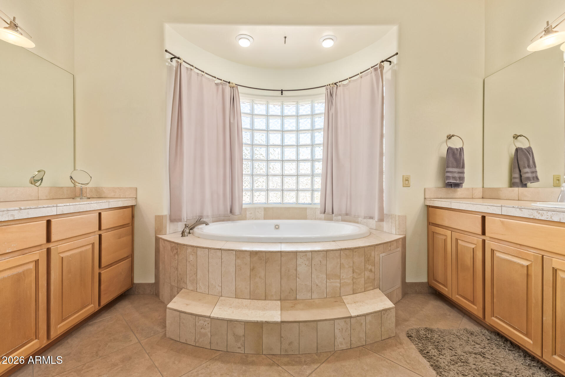 16037 West Wade Lane Goodyear, AZ 85338 - Photo 26 of 67 a spacious bathroom with a double vanity sink a mirror and a bathtub
