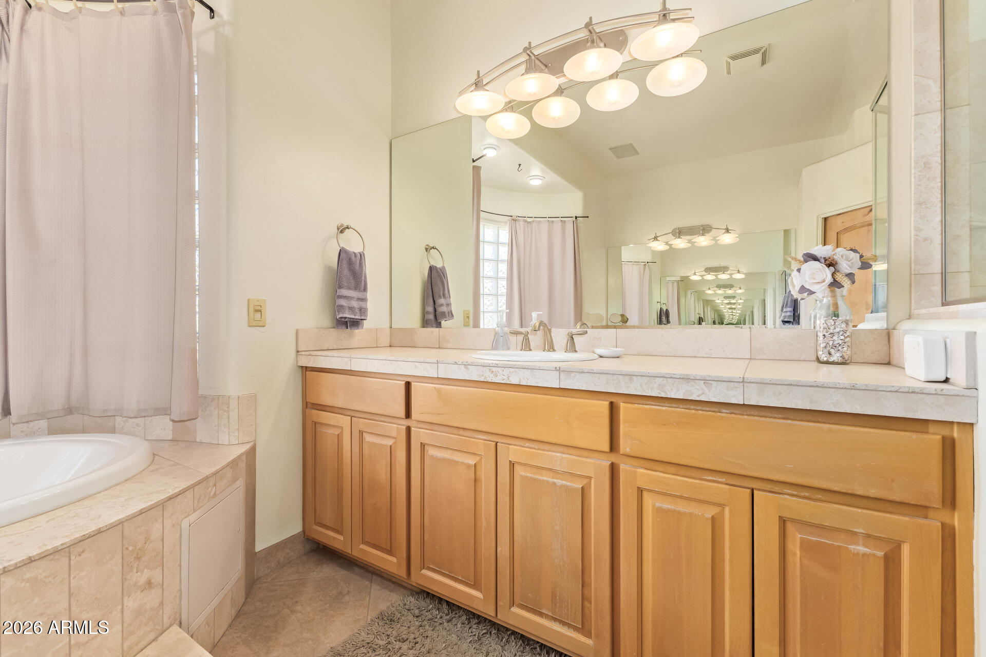 16037 West Wade Lane Goodyear, AZ 85338 - Photo 27 of 67 a bathroom with a sink vanity granite tub and a mirror