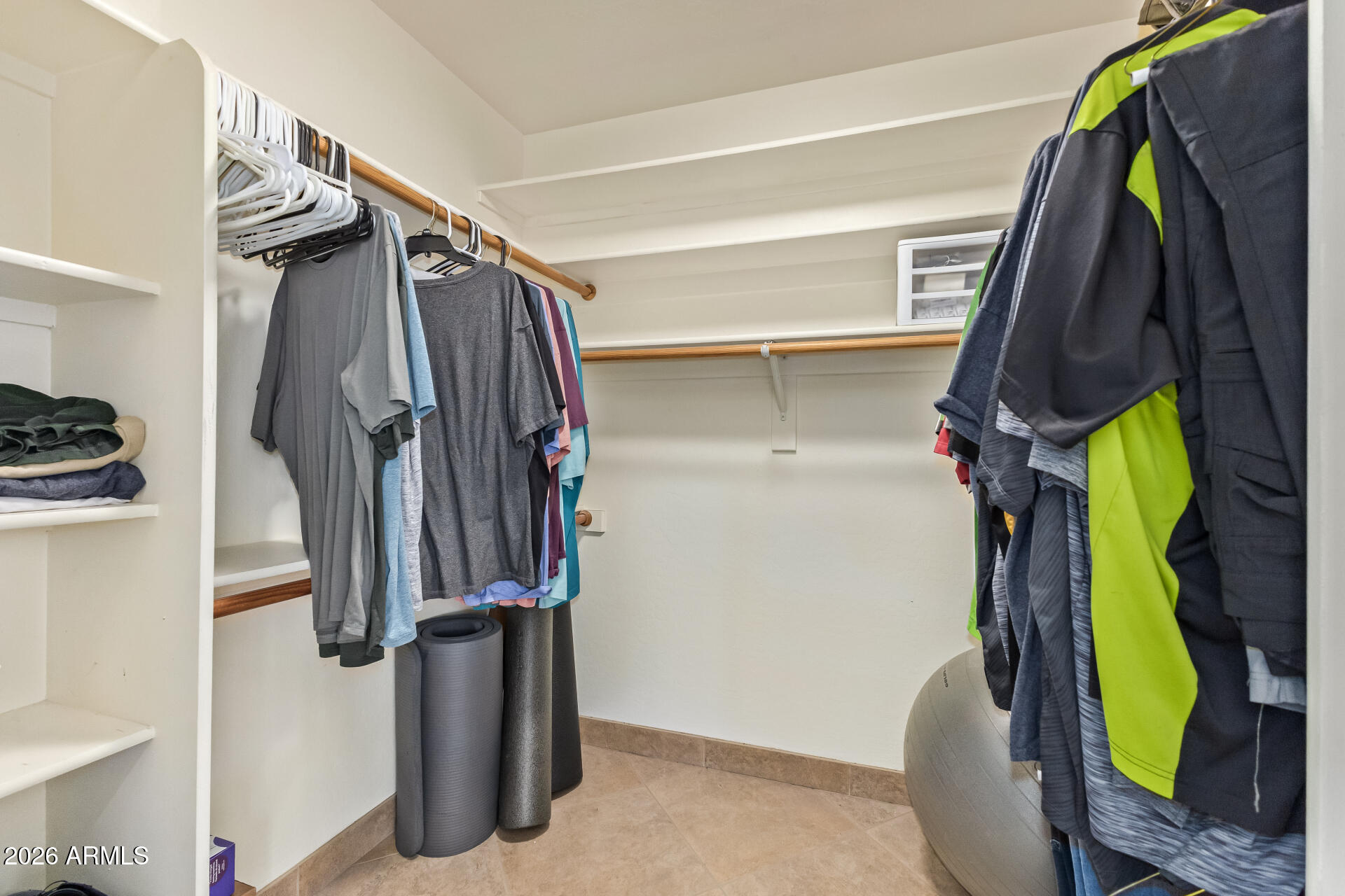 16037 West Wade Lane Goodyear, AZ 85338 - Photo 31 of 67 a view of walk in closet with clothes and shoes