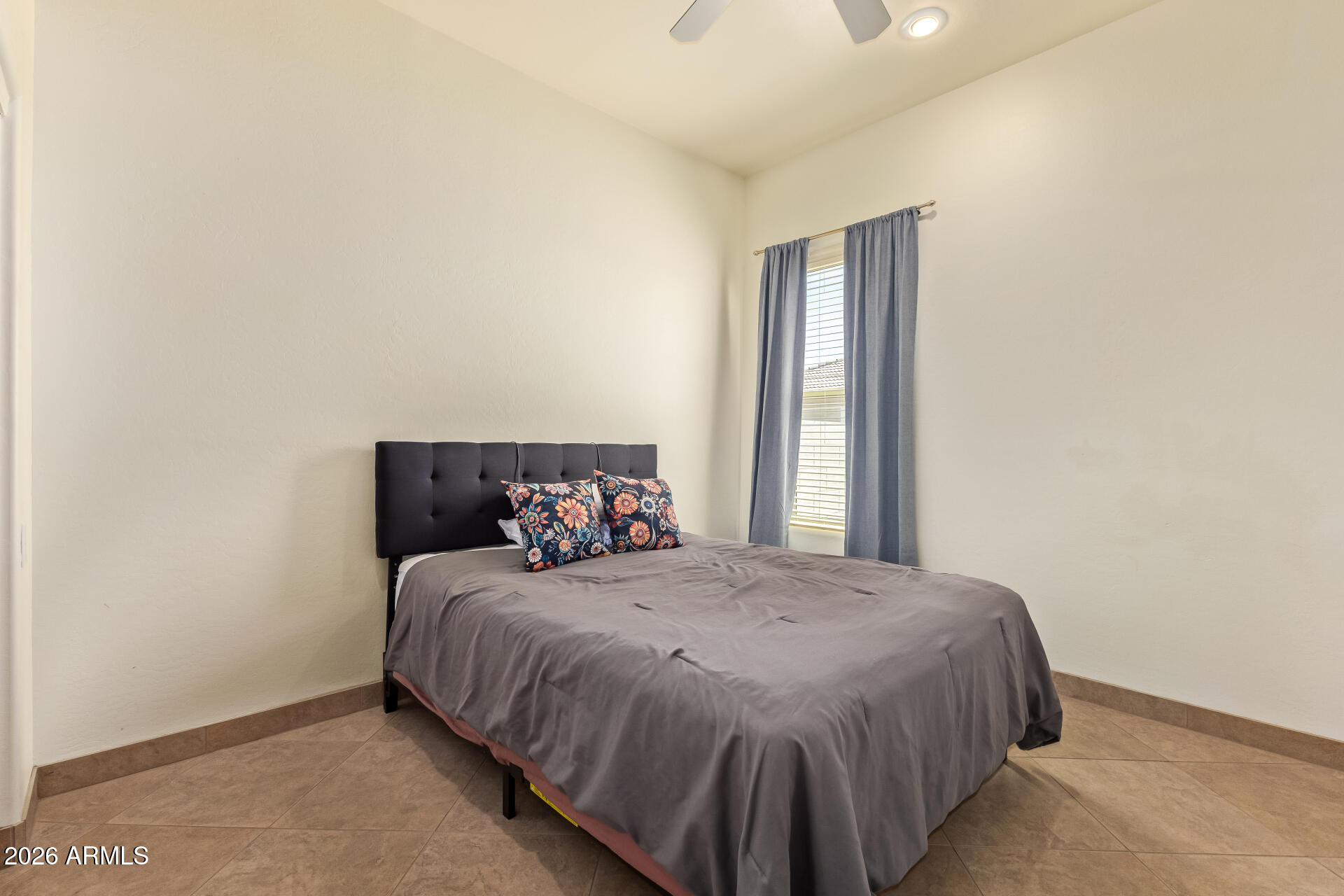 16037 West Wade Lane Goodyear, AZ 85338 - Photo 33 of 67 a bedroom with a bed and window