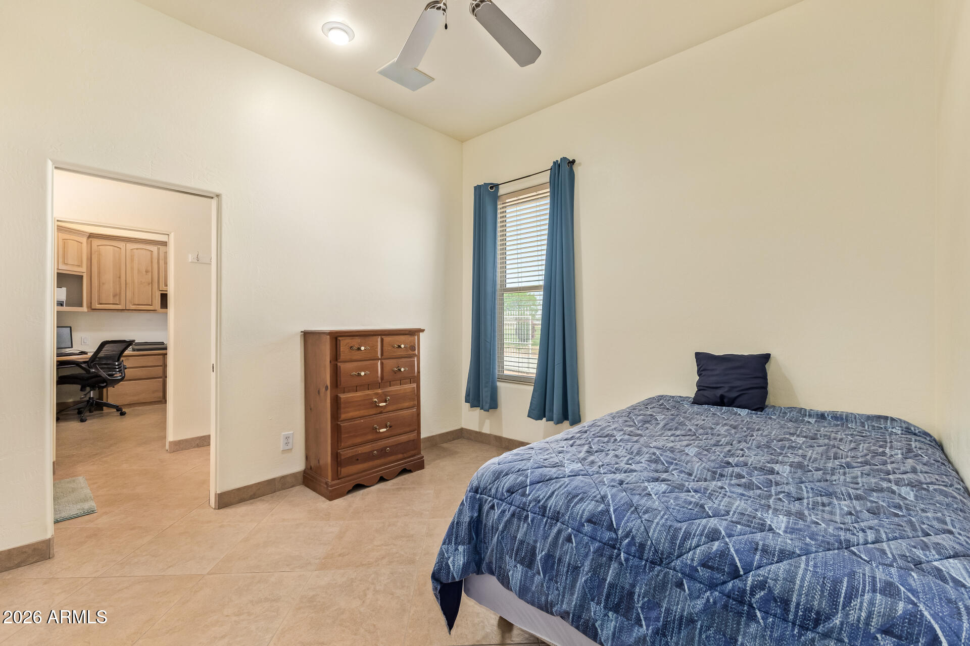 16037 West Wade Lane Goodyear, AZ 85338 - Photo 37 of 67 a bedroom with a large bed and a flat tv screen on dresser