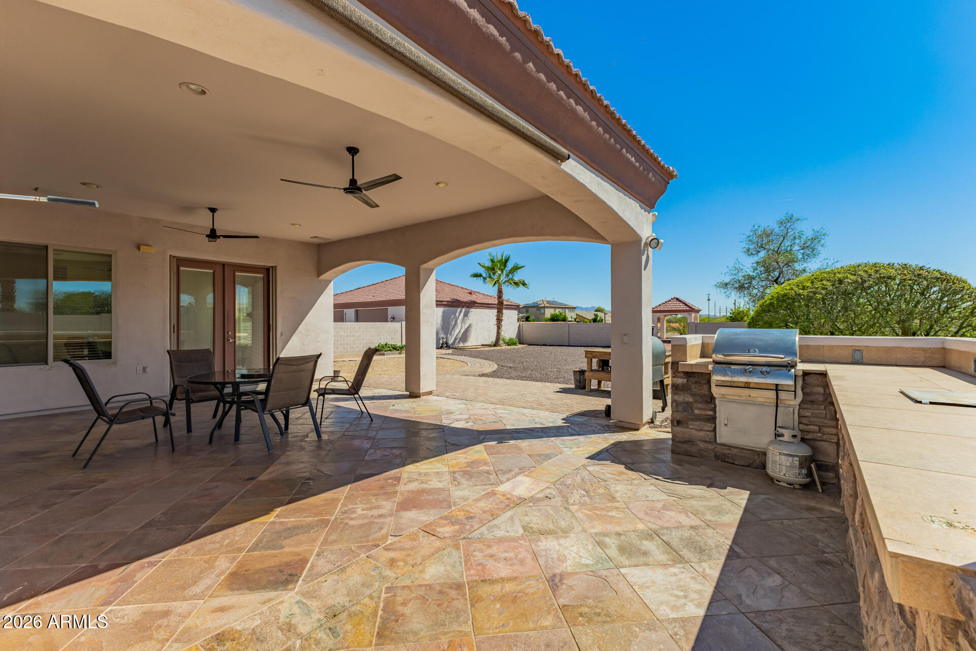 16037 West Wade Lane Goodyear, AZ 85338 - Photo 54 of 67 a view of a patio with table and chairs with wooden floor and fence