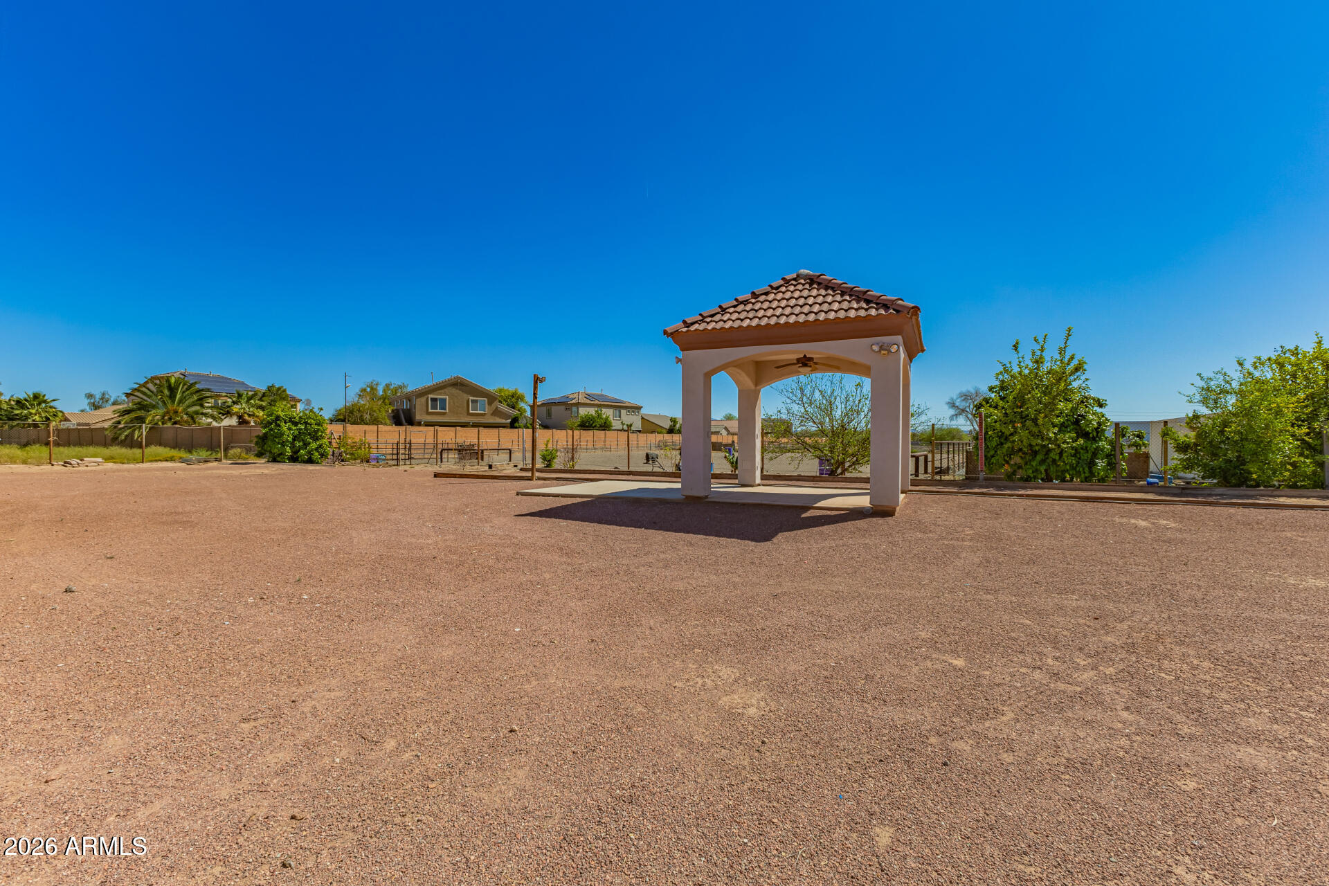 16037 West Wade Lane Goodyear, AZ 85338 - Photo 62 of 67 a view of a lake with couches chairs under an umbrella