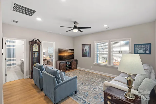 a living room with furniture ceiling fan and a flat screen tv