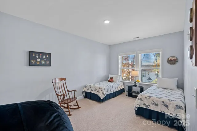 a bedroom with two beds and painting on the wall