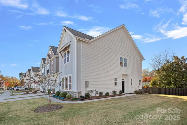 a view of a white house with a yard and plants