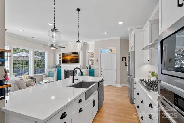 a large kitchen with kitchen island a large counter space a sink stainless steel appliances and cabinets