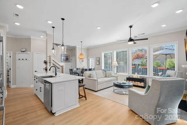 a living room with stainless steel appliances granite countertop furniture a sink a counter top space a large window and living room view