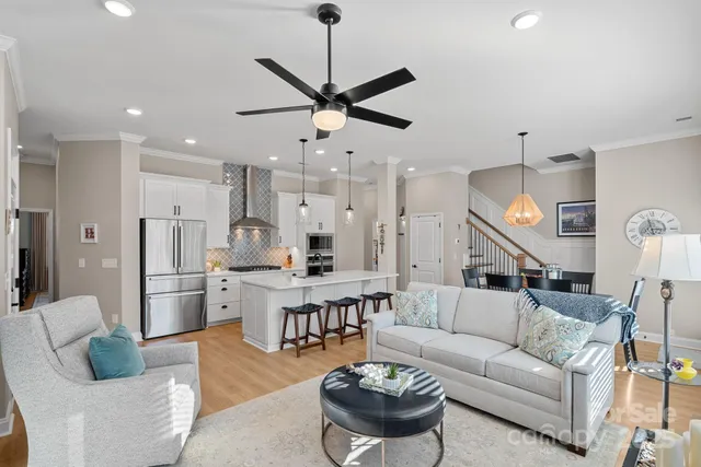 a living room with furniture kitchen view and a chandelier