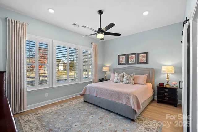 a bedroom with a bed ceiling fan and a window
