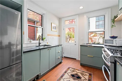 a kitchen with stainless steel appliances granite countertop a stove a sink and a refrigerator