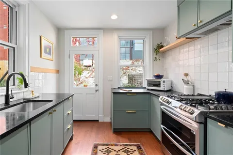 a kitchen with stainless steel appliances a sink stove and cabinets
