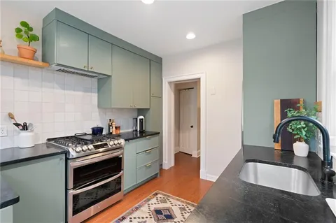 a kitchen with stainless steel appliances granite countertop a sink stove and cabinets