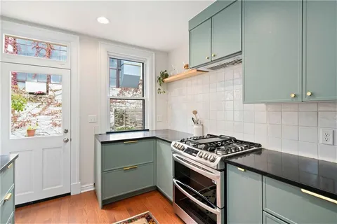a kitchen with granite countertop cabinets appliances and a window