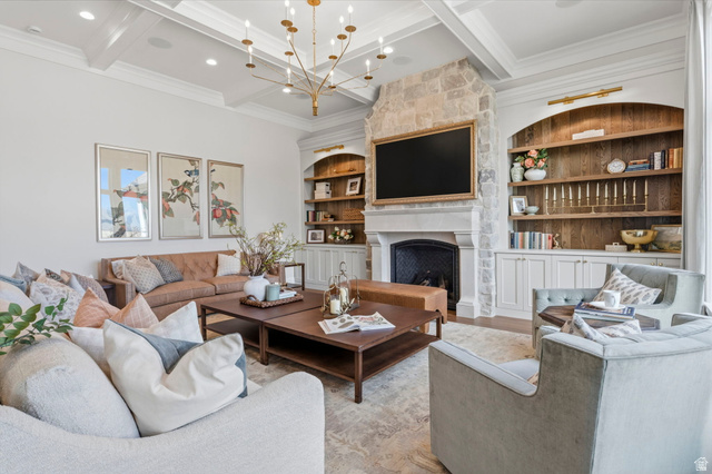 115 East Hidden Ridge Lane, Unit 42 Mapleton, UT 84664 - Photo 3 of 103 Living area featuring a stone-clad fireplace with a classic mantel, built-in shelving with wood paneling, and an ornate chandelier