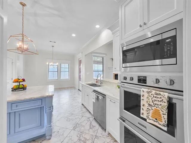 a kitchen with stainless steel appliances kitchen island granite countertop a stove a sink and a microwave
