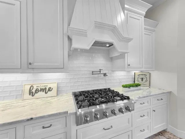a kitchen with white cabinets and appliances