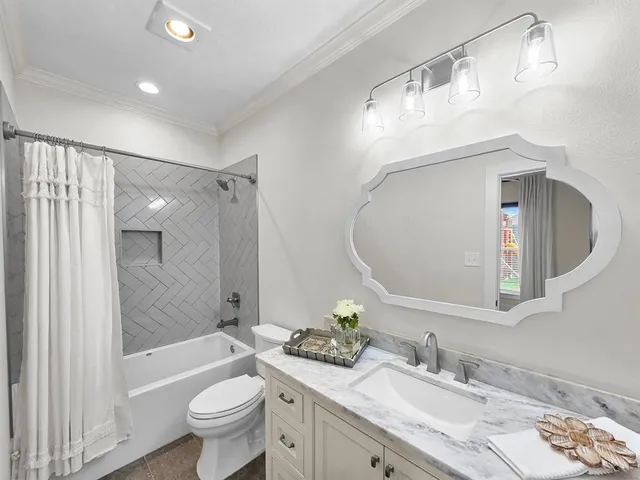 a bathroom with a granite countertop sink mirror toilet and bathtub