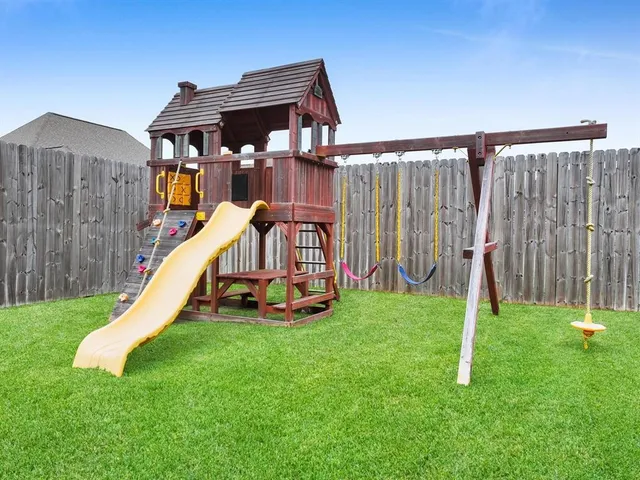 an aerial view of a house with swimming pool and a yard