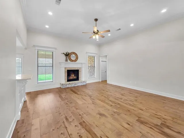 an empty room with windows and fireplace