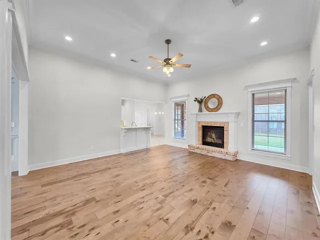 a view of an empty room with a fireplace and a window
