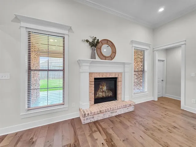 a view of an empty room with a window and fireplace