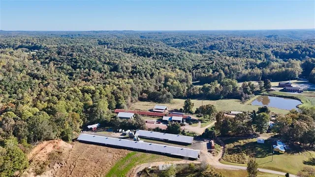 an aerial view of a houses with a garden and lake view