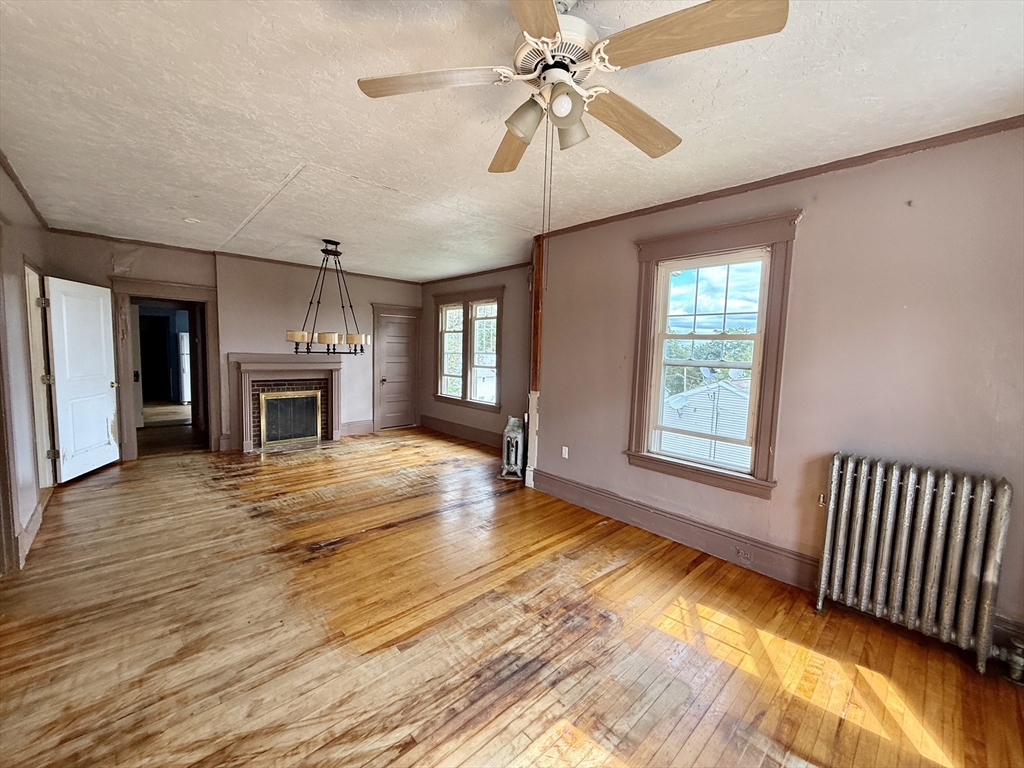 22 Baker Street Worcester, MA 01603 - Photo 18 of 35 an empty room with wooden floor fireplace and windows