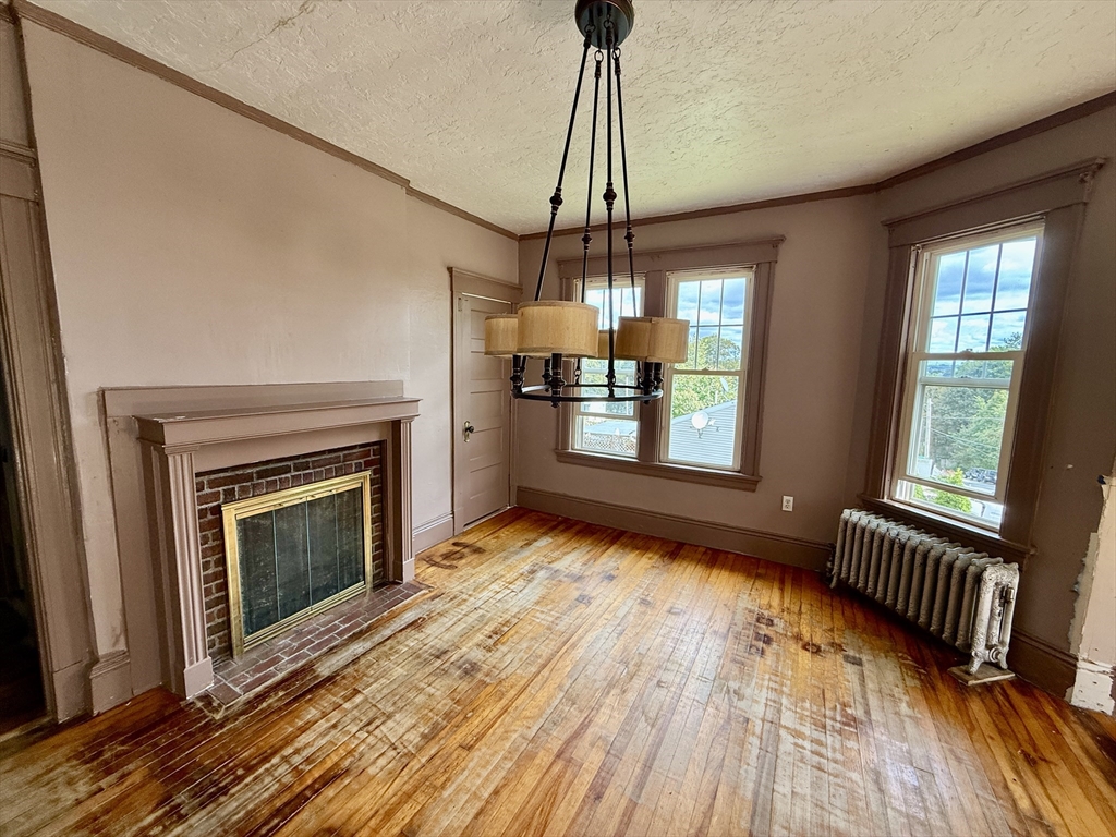 22 Baker Street Worcester, MA 01603 - Photo 20 of 35 a view of empty room with wooden floor and fireplace