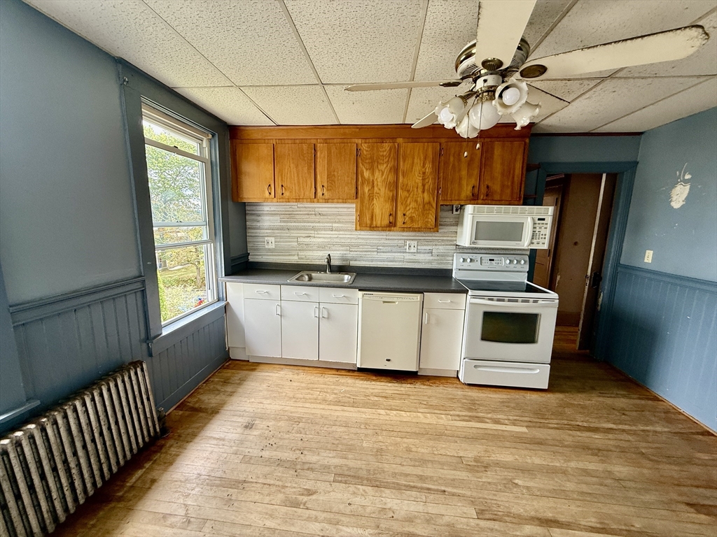 22 Baker Street Worcester, MA 01603 - Photo 24 of 35 a kitchen with stainless steel appliances a white stove top oven cabinets a sink and a window