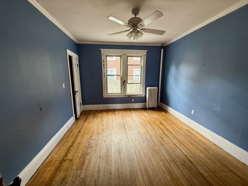22 Baker Street Worcester, MA 01603 - Photo 10 of 35 a view of empty room with wooden floor and fan
