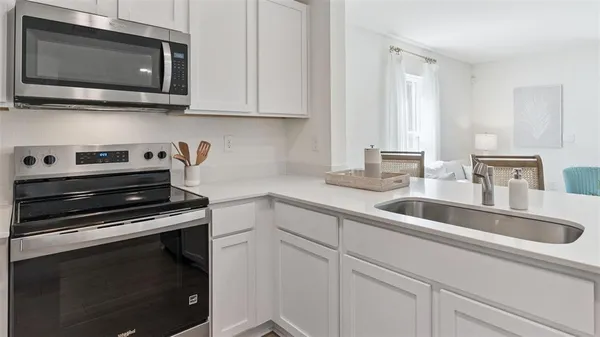 a kitchen with appliances a sink and cabinets