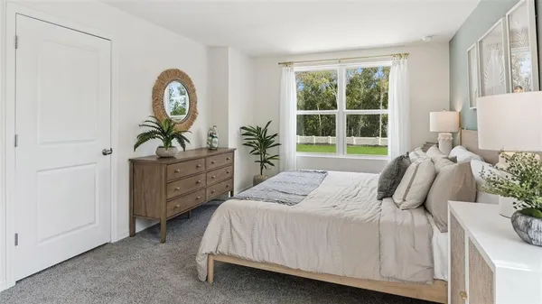 a bedroom with a bed a mirror and a window