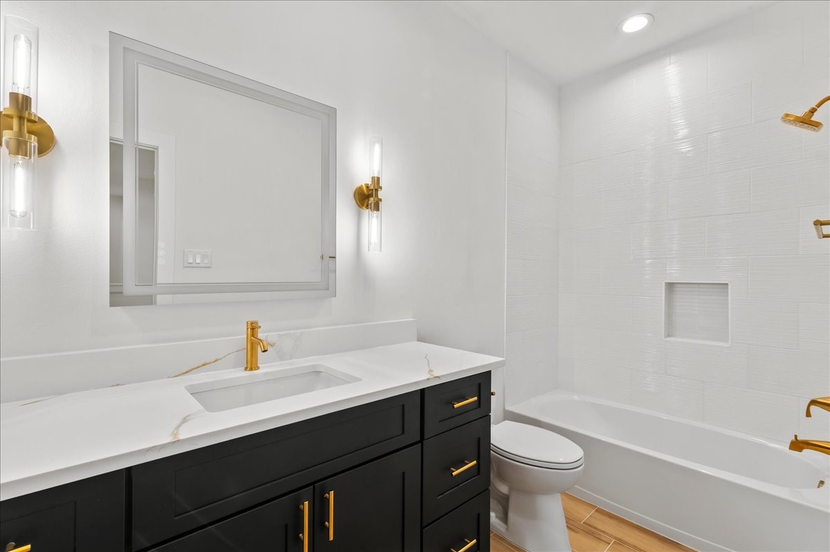 8323 Observatory Street, Unit A/B Houston, TX 77088 - Photo 14 of 38 Unit A - Secondary bathroom features a tub/shower combination accented with elegant gold fixtures and a modern LED vanity mirror, creating a stylish and functional space for family and guests.